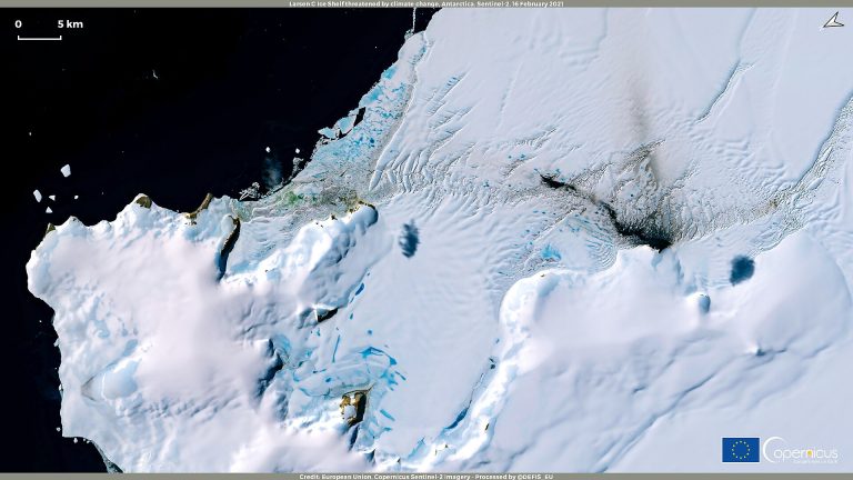 Antarctic ice and glaciers with researchers in the distance